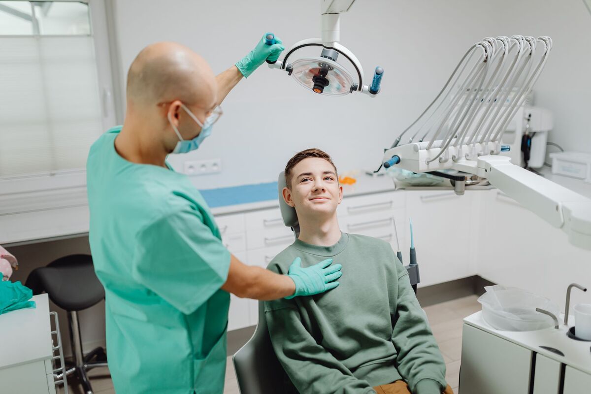 طبيب أسنان في أبوظبي يفحص أشعة رقمية لابتسامة مريض قبل خطة علاج تجميلي