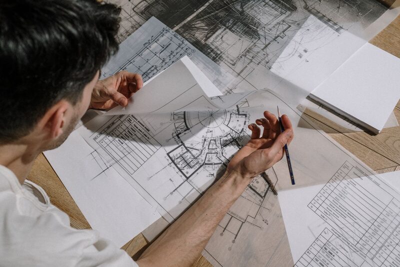 مهندس معماري يراجع مخططات تصميم فيلا فاخرة في مكتب هندسي بأبوظبي