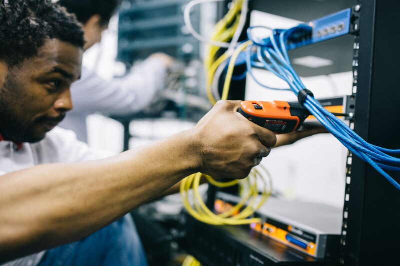 مهندس تقنية معلومات يعمل داخل غرفة خوادم لشركة تقدم خدمات دعم تقني مُدار في أبوظبي